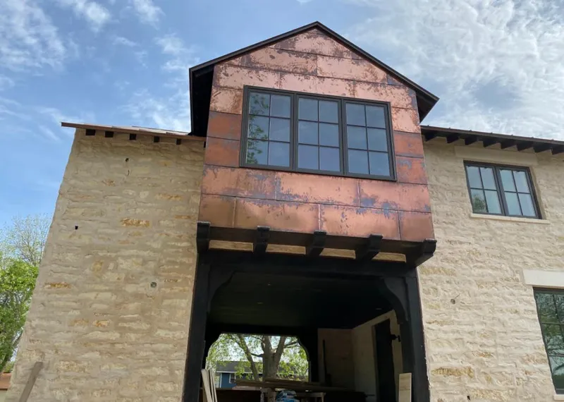 Copper metal panel facade on a stone building for Roof Repair in Manlius